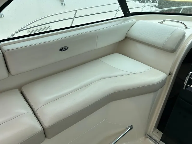 Slide: The Image of 2011 Pursuit OS 315 Offshore boat interior with white cushioned seating. - 10