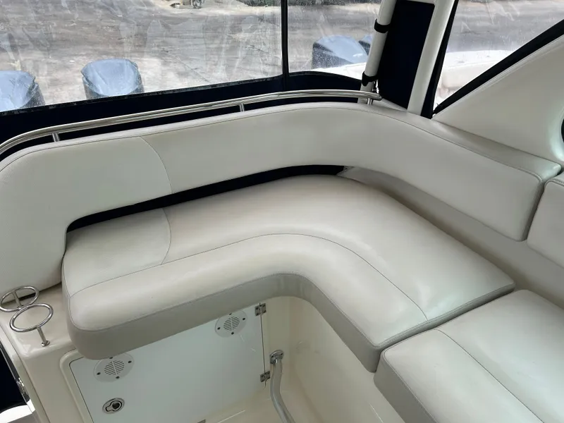 Slide: The Image of 2011 Pursuit OS 315 Offshore boat interior with white cushioned seating. - 11