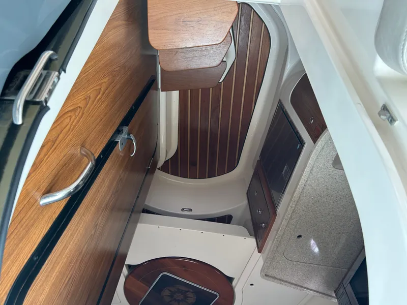 Slide: The Image of 2011 Pursuit OS 315 Offshore cabin interior with wood finish and storage compartments. - 13