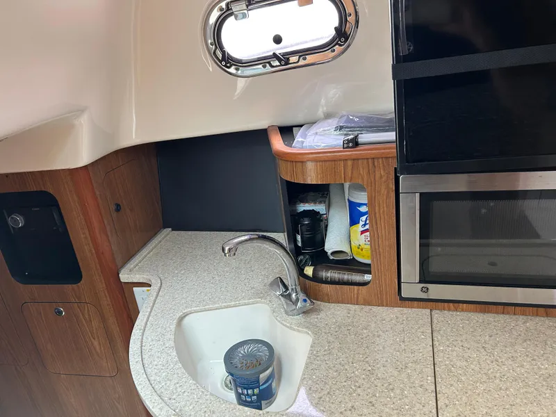 Slide: The Image of 2011 Pursuit OS 315 Offshore boat interior with sink and storage area. - 16