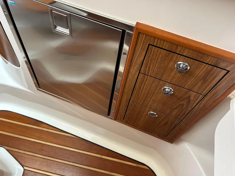 Slide: The Image of 2011 Pursuit OS 315 Offshore interior with stainless steel fridge and wooden cabinetry. - 17
