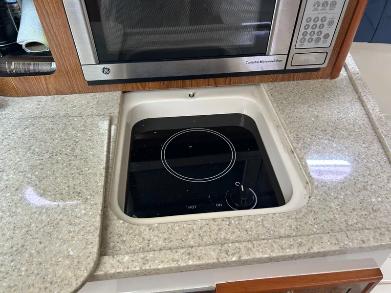 Slide: The Image of 2011 Pursuit OS 315 Offshore kitchen with microwave and electric stove. - 23