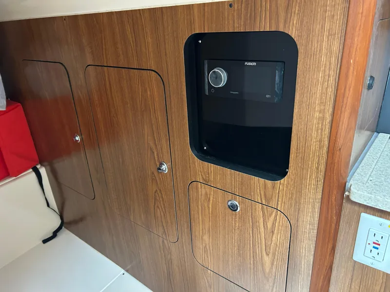 Slide: The Image of Wooden interior of 2011 Pursuit OS 315 Offshore boat with storage compartments and control panel. - 24