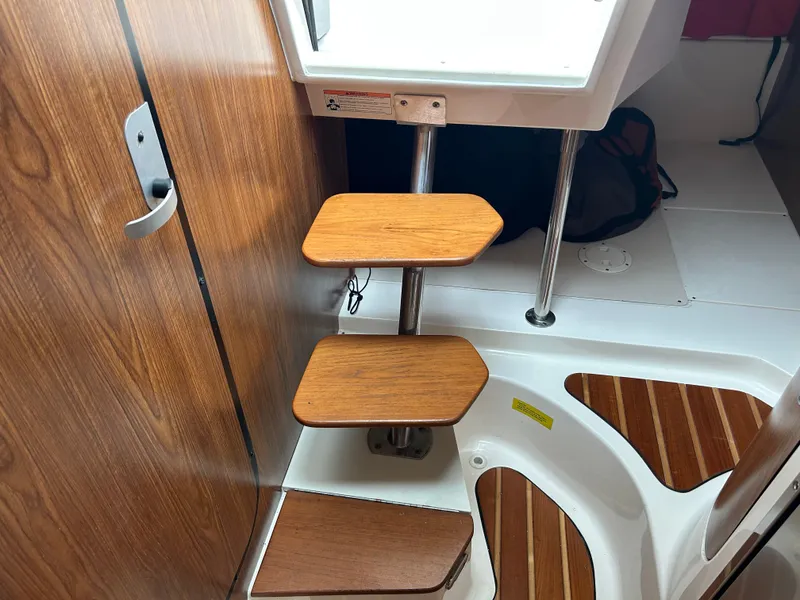 Slide: The Image of Interior of 2011 Pursuit OS 315 Offshore boat with wooden steps and sleek design. - 25