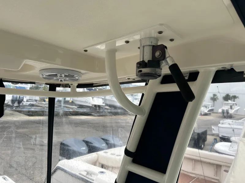 Slide: The Image of 2011 Pursuit OS 315 Offshore boat interior, featuring a mounted rod holder and speaker. - 26