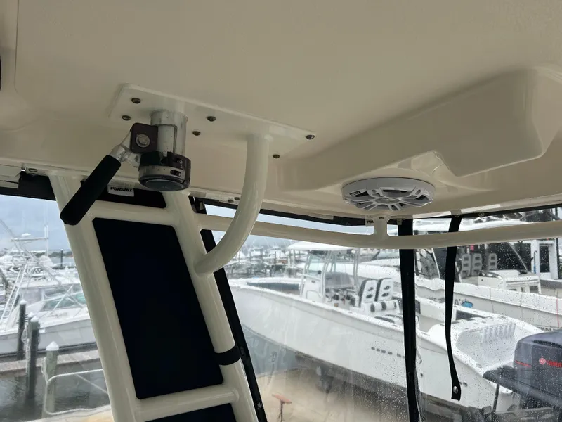 Slide: The Image of 2011 Pursuit OS 315 Offshore boat interior with mounted equipment and marina view. - 27