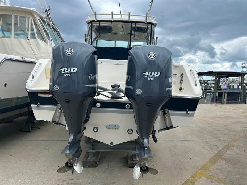 Slide: The Image of 2011 Pursuit OS 315 Offshore boat with twin Yamaha 300 V6 engines, docked outdoors. - 3