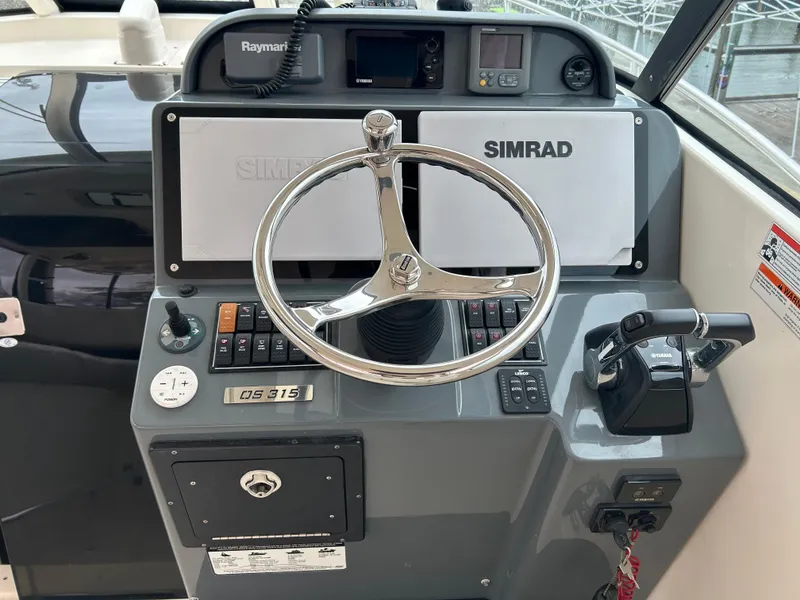 Slide: The Image of 2011 Pursuit OS 315 Offshore boat helm with Simrad navigation and Raymarine electronics. - 9
