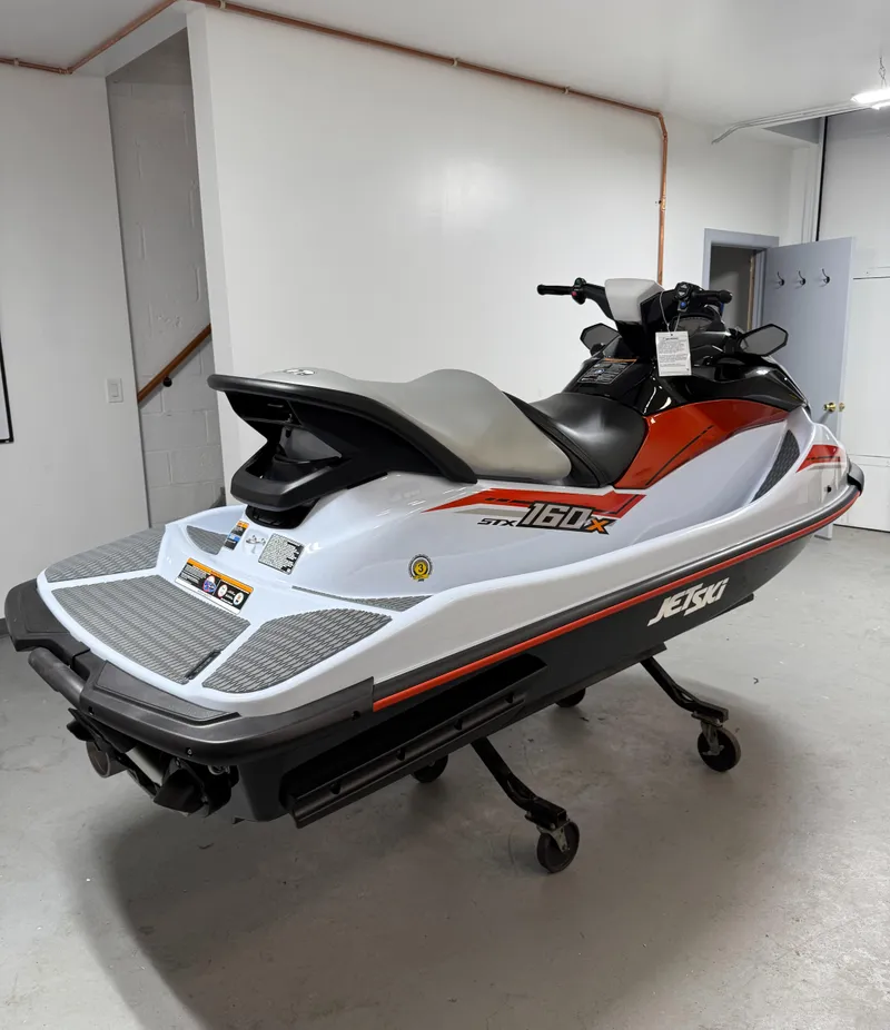 Slide: The Image of 2025 Kawasaki STX 160X jet ski in a showroom, featuring sleek design and vibrant colors. - 2