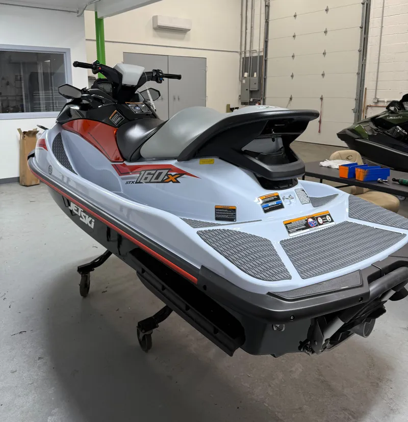 Slide: The Image of 2025 Kawasaki STX 160X jet ski in a garage setting. - 3