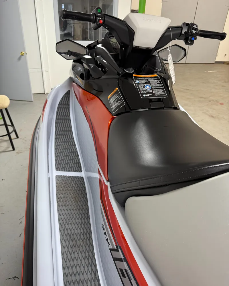 Slide: The Image of 2025 Kawasaki STX 160X jet ski, sleek design, black and orange color scheme, indoor showroom. - 4