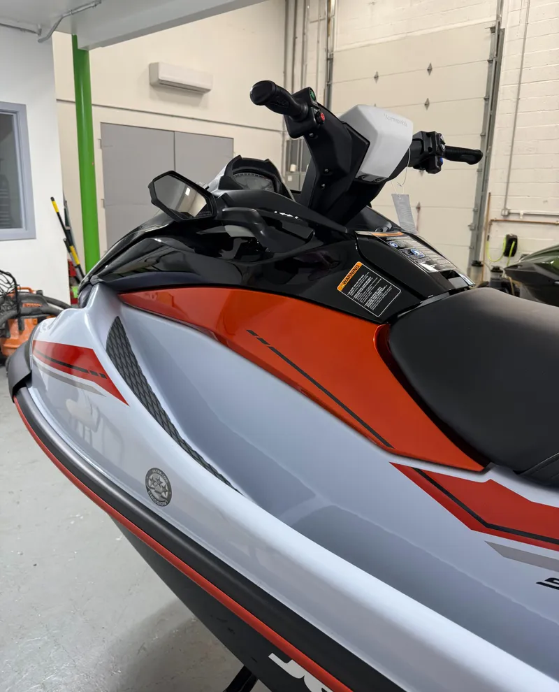 Slide: The Image of 2025 Kawasaki STX 160X jet ski in showroom, featuring sleek red and white design. - 5