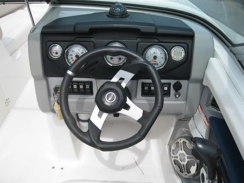 Slide: The Image of Steering wheel and dashboard of 2012 Chaparral 206 SSi boat, featuring gauges and controls. - 12