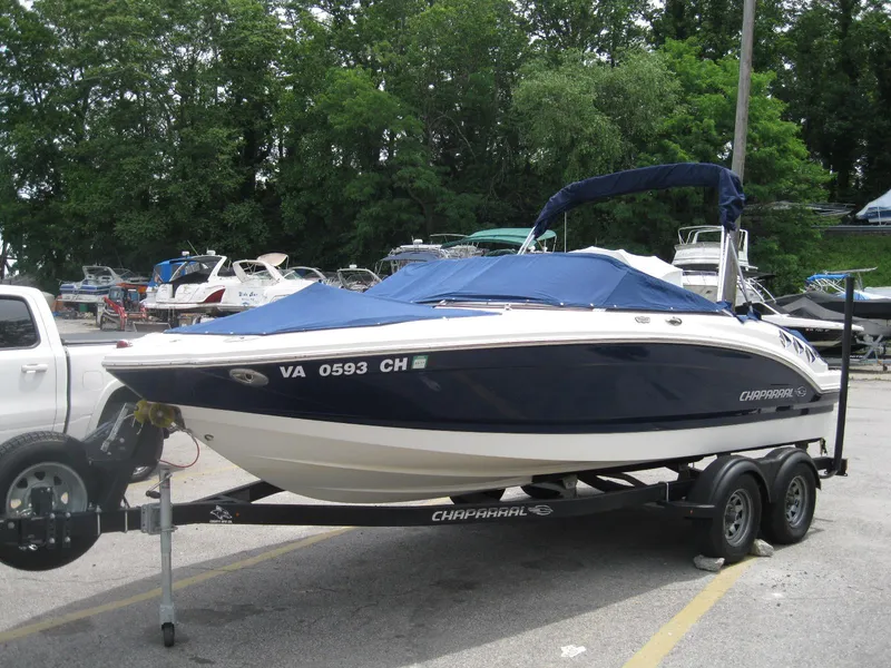 Slide: The Image of Chaparral 206 SSi 2012 boat on trailer, covered, parked near trees. - 2