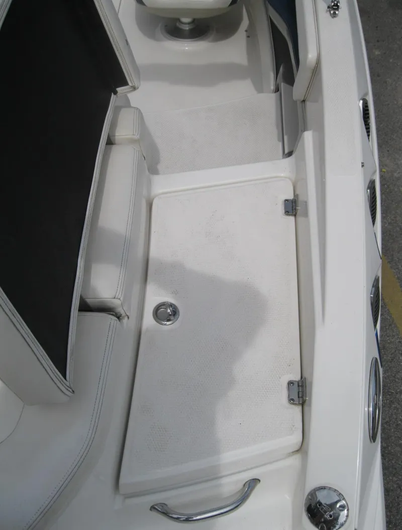Slide: The Image of 2012 Chaparral 206 SSi boat interior, featuring white seating and storage compartment. - 20