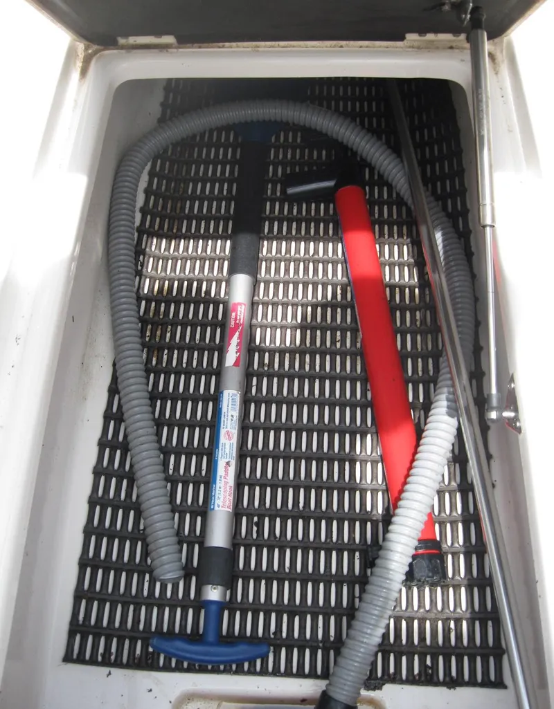 Slide: The Image of Storage compartment of a 2012 Chaparral 206 SSi boat with hoses and a manual pump. - 21