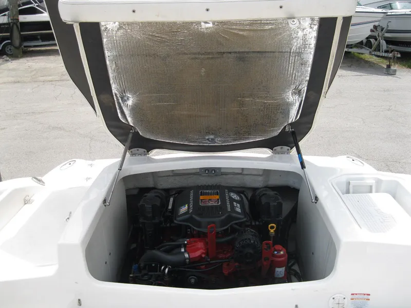 Slide: The Image of 2012 Chaparral 206 SSi boat engine compartment with open hatch, showcasing engine components. - 24
