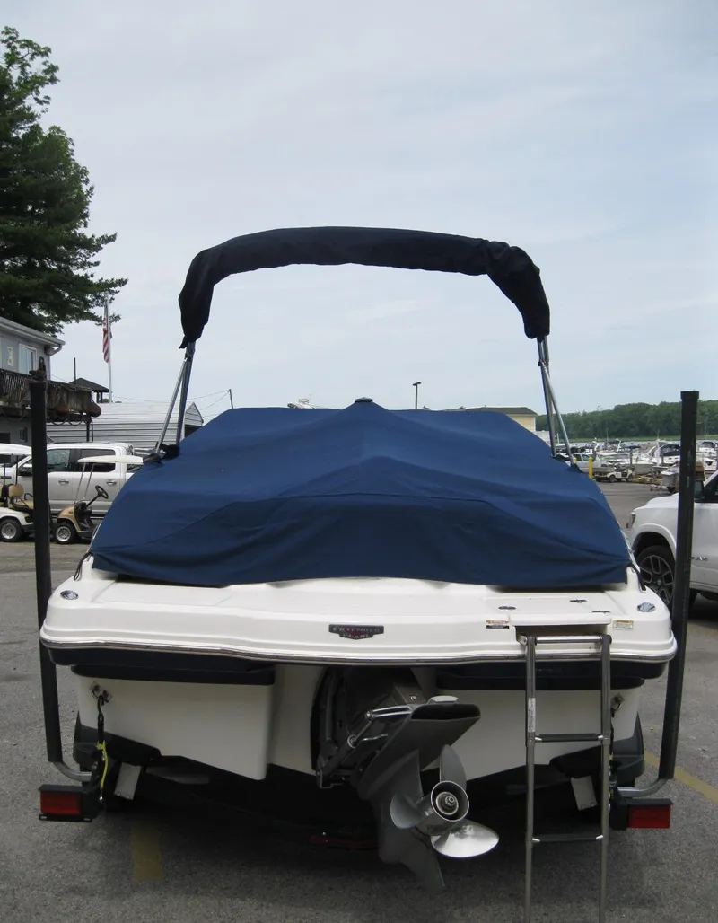 Slide: The Image of 2012 Chaparral 206 SSi boat with blue cover and bimini top, parked at marina. - 6