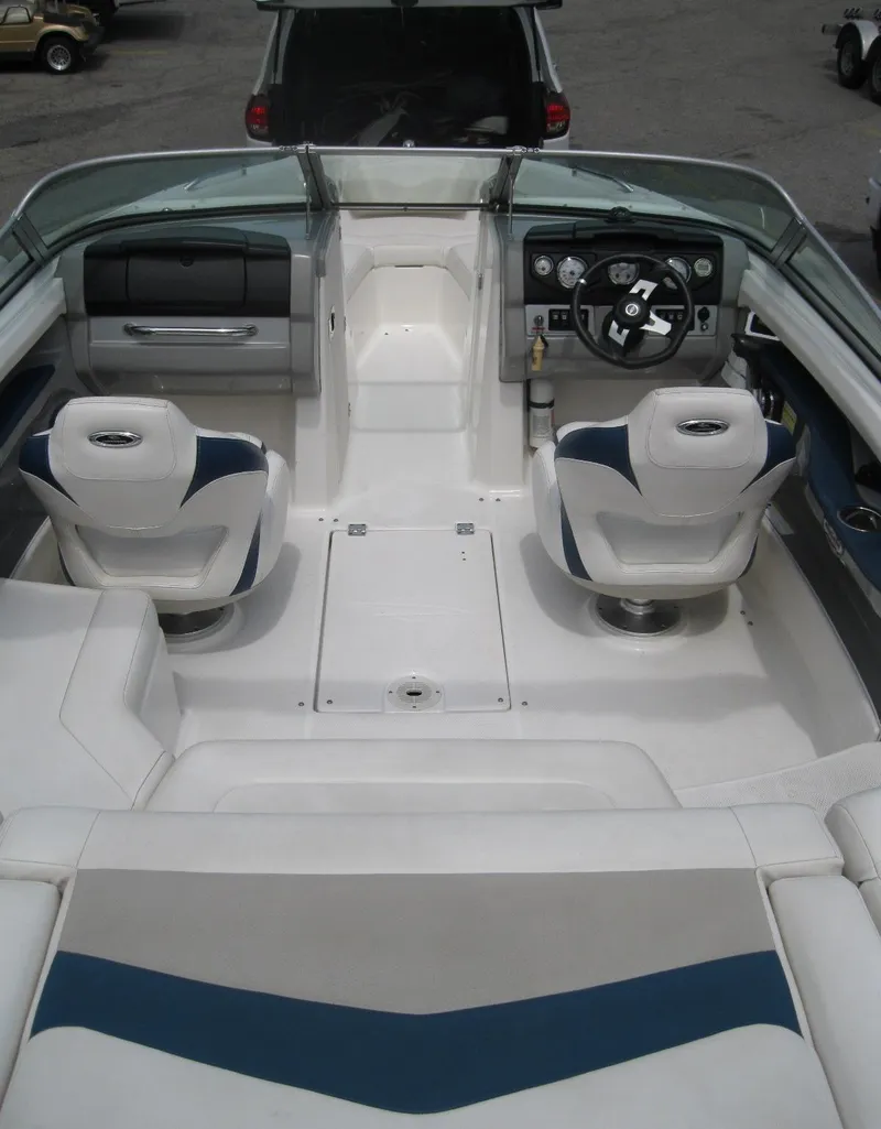 Slide: The Image of 2012 Chaparral 206 SSi boat interior with white and blue seating, steering wheel, and dashboard. - 7