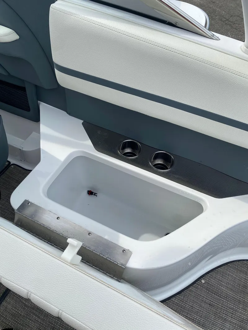 Slide: The Image of 2018 Cobalt R5 boat interior with built-in storage compartment and cup holders. - 17