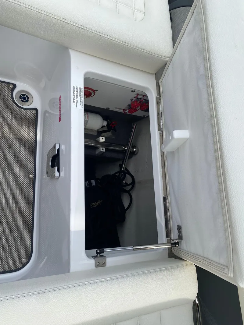 Slide: The Image of Open storage compartment in a 2018 Cobalt R5 boat, showing interior equipment and fittings. - 18