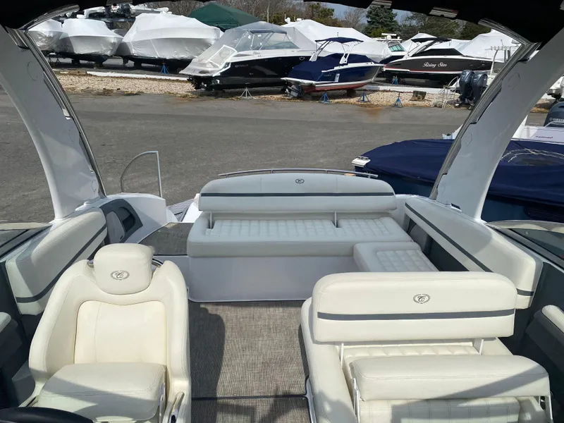 Slide: The Image of 2018 Cobalt R5 boat interior with white seating, parked among covered boats. - 6