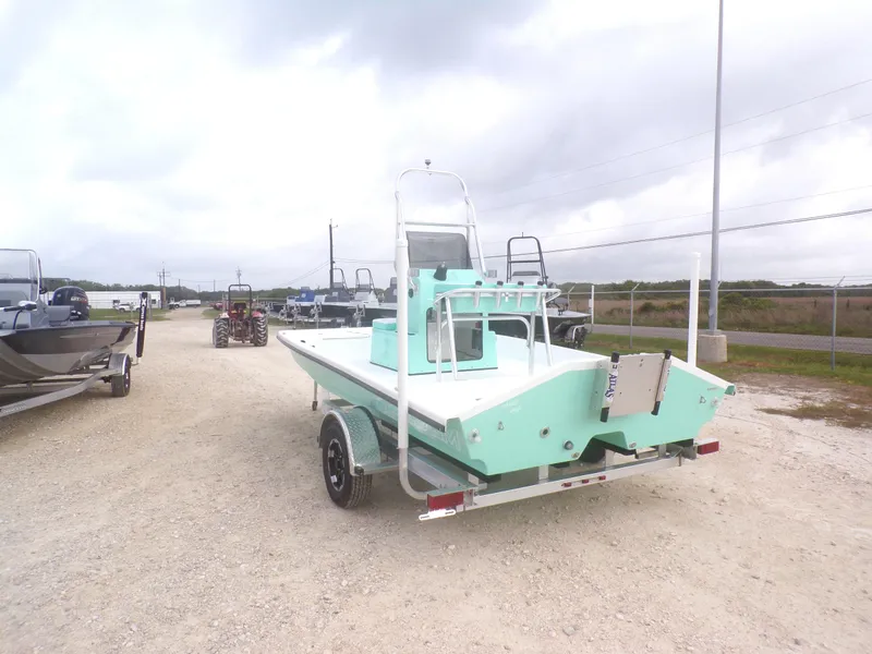 Slide: The Image of 2025 Freedom Eagle 16 boat on trailer, light green color, parked outdoors. - 12