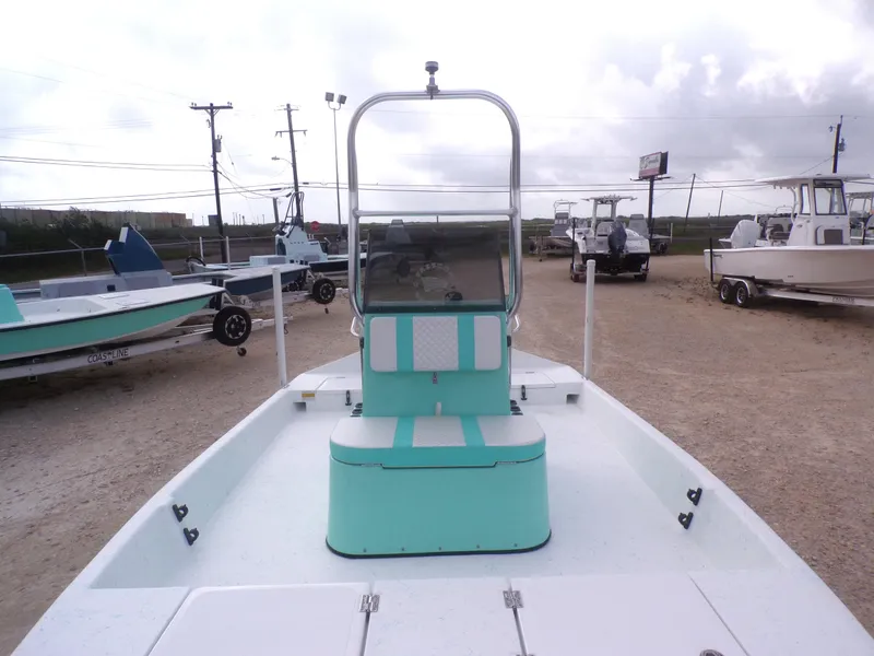 Slide: The Image of 2025 Freedom Eagle 16 boat with teal seating, parked on a gravel lot. - 13