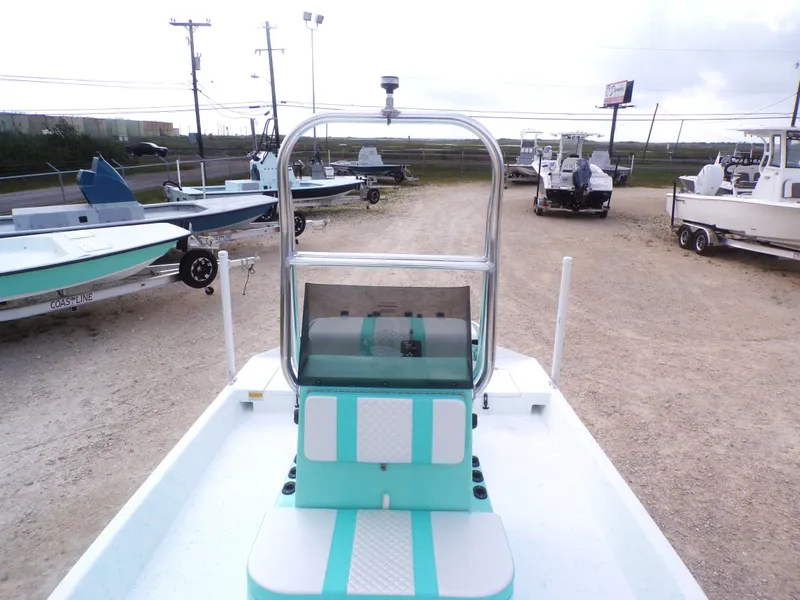 Slide: The Image of 2025 Freedom Eagle 16 boat in a lot with other boats, featuring teal and white seating. - 14