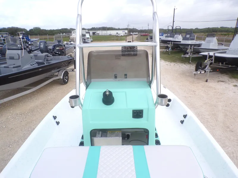 Slide: The Image of 2025 Freedom Eagle 16 boat with teal console, parked among other boats. - 16