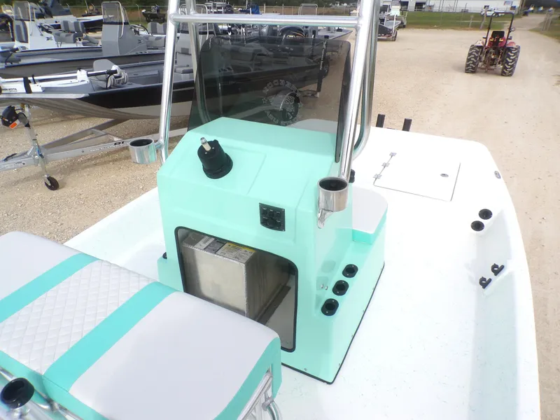 Slide: The Image of 2025 Freedom Eagle 16 boat with mint green console and seating, parked on gravel. - 22