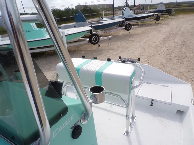 Slide: The Image of 2025 Freedom Eagle 16 boat with teal accents, parked on a sandy lot. - 24