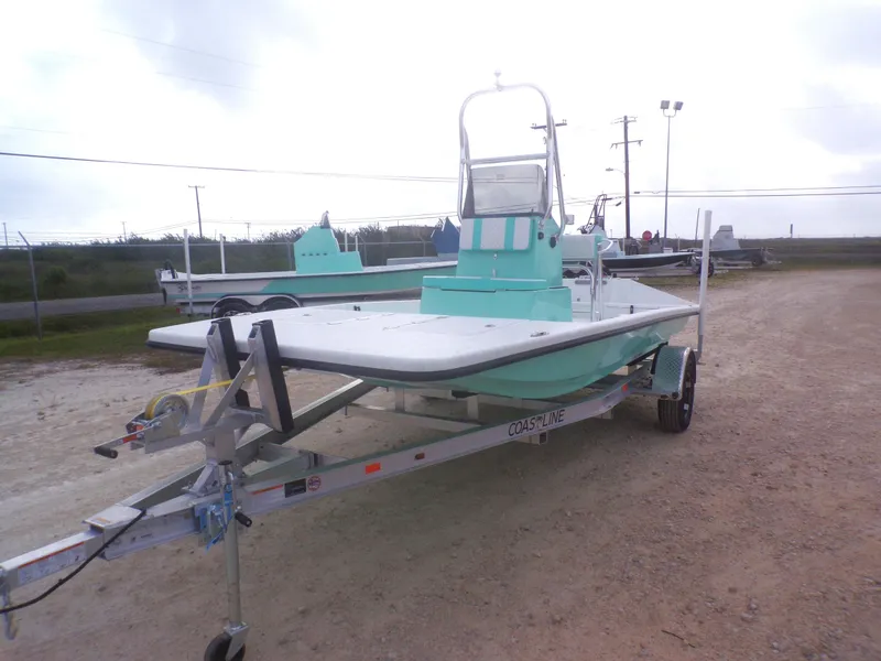 Slide: The Image of 2025 Freedom Eagle 16 boat on trailer, light blue, parked outdoors. - 3