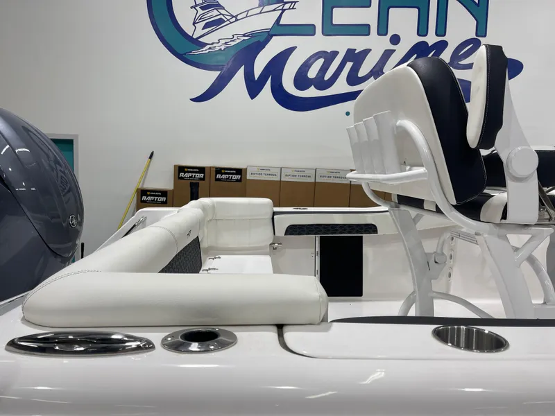 Slide: The Image of 2025 Tidewater 220LXF boat interior with white seating and rod holders in showroom. - 12