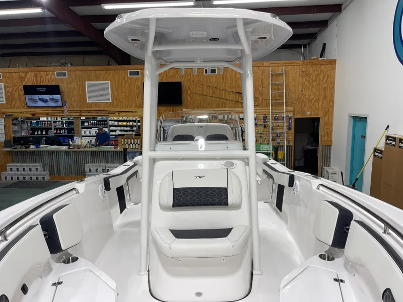 Slide: The Image of 2025 Tidewater 220LXF boat interior, featuring seating and storage, displayed in a showroom. - 17