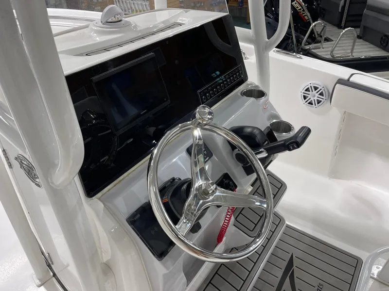 Slide: The Image of 2025 Tidewater 220LXF boat dashboard with steering wheel and electronic controls. - 21