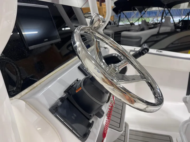 Slide: The Image of Steering wheel of 2025 Tidewater 220LXF boat with modern dashboard and controls. - 22