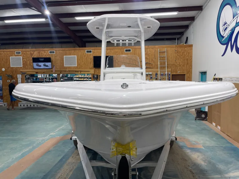 Slide: The Image of 2025 Tidewater 220LXF boat in showroom, front view, white hull, indoor setting. - 5