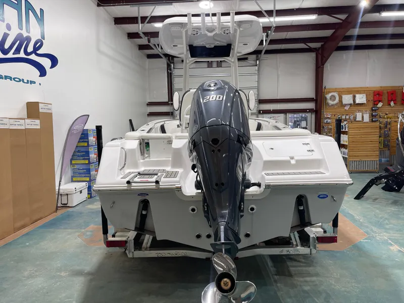 Slide: The Image of 2025 Tidewater 220LXF boat with 200HP engine in showroom setting. - 8