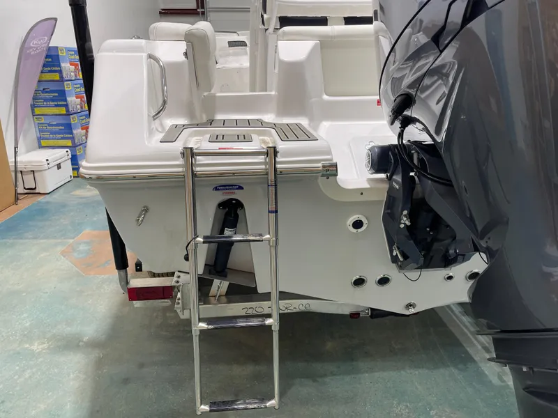 Slide: The Image of 2025 Tidewater 220LXF boat with ladder and outboard motor in a showroom. - 9