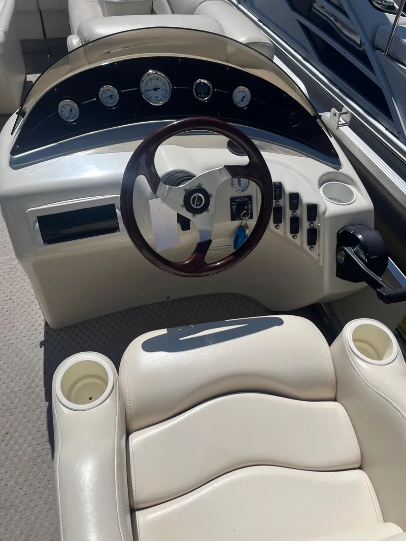 Slide: The Image of 2004 Bennington 2250 RL boat dashboard with steering wheel and control panel. - 2