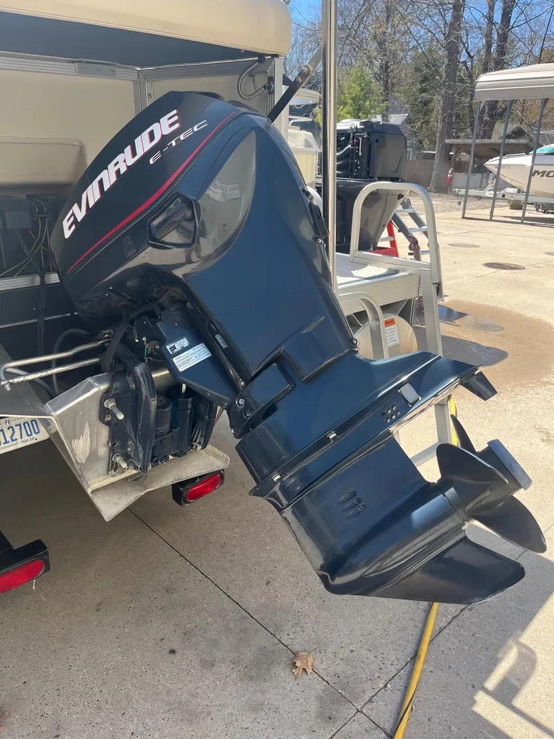 Slide: The Image of 2004 Bennington 2250 RL with Evinrude outboard motor in a sunny outdoor setting. - 6