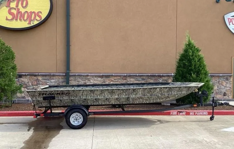 Slide: The Image of 2025 Tracker GRIZZLY 1860 Utility boat on trailer, parked outside a store. - 3