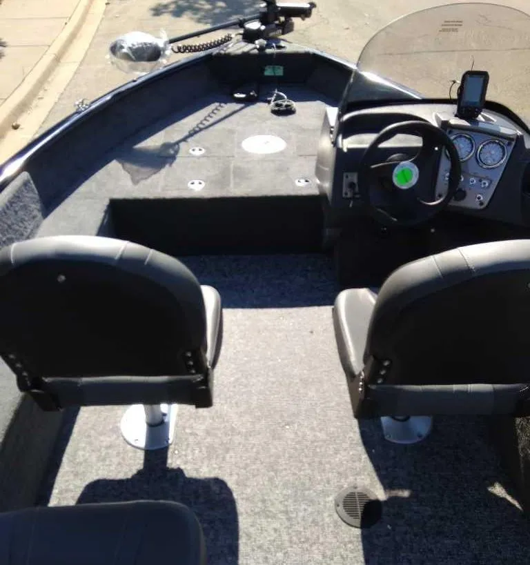 Slide: The Image of 2025 Tracker Pro Guide V-16 SC boat interior with steering console and seating. - 2