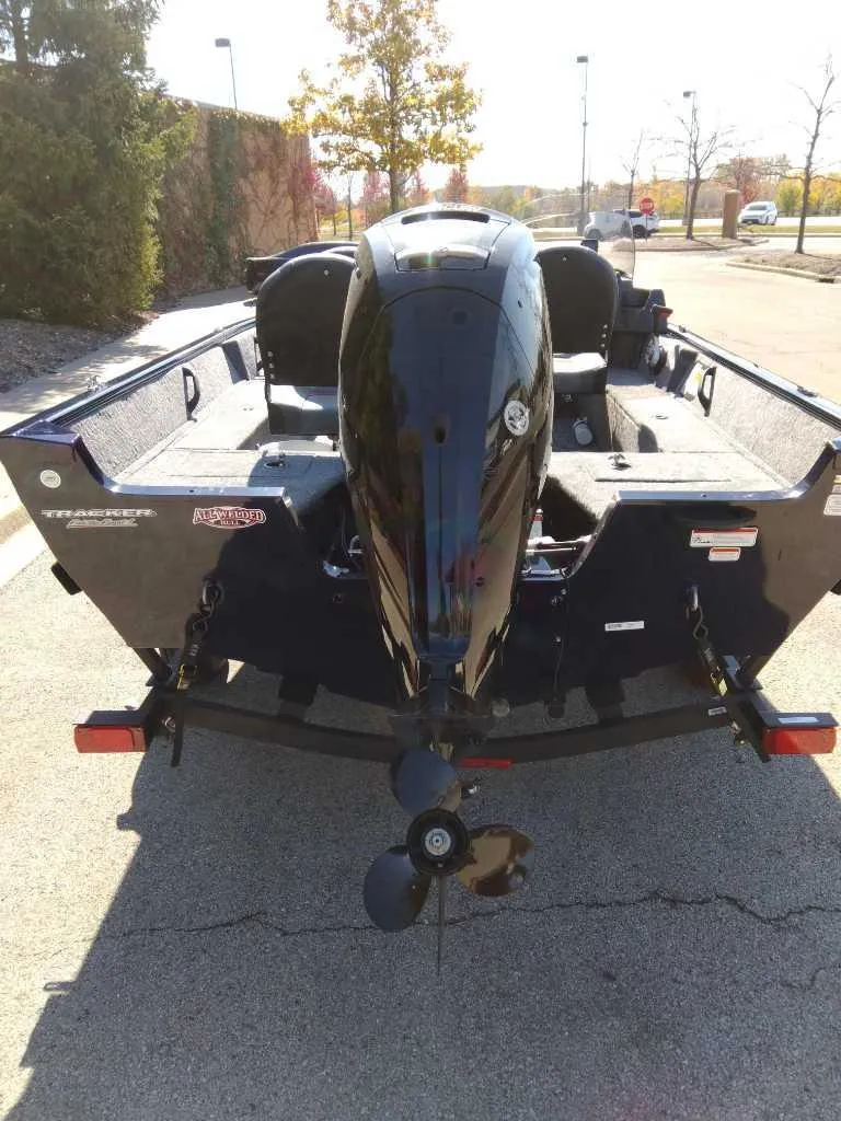 Slide: The Image of 2025 Tracker Pro Guide V-16 SC boat, rear view with motor, parked outdoors. - 4