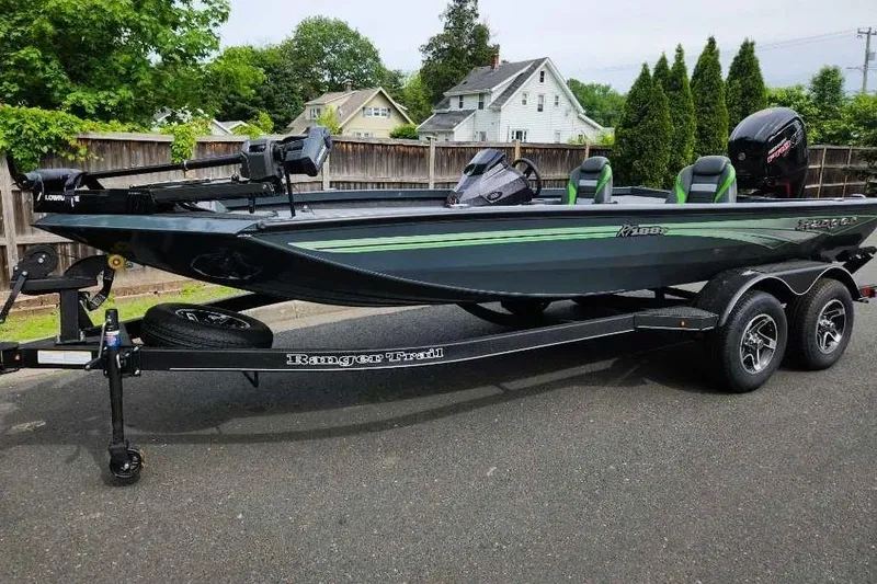 The Image of 2025 Ranger RT188P boat on trailer, sleek design, green accents, parked on street. - 0