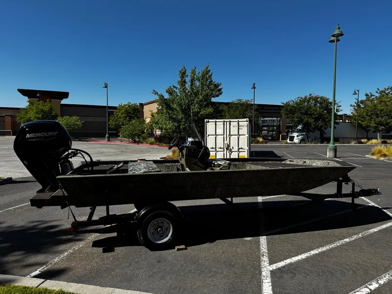 Slide: The Image of 2025 Tracker Grizzly 1860 CC boat with Mercury engine in parking lot. - 3