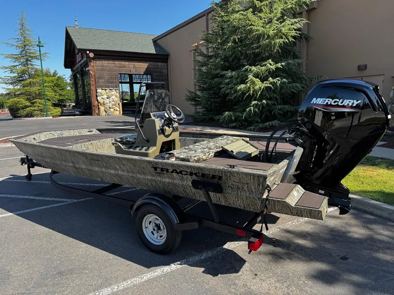 Slide: The Image of 2025 Tracker Grizzly 1860 CC boat with Mercury engine, parked outdoors. - 5
