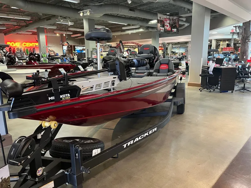 Slide: The Image of 2025 Tracker Savage 215 boat displayed in showroom on trailer. - 2