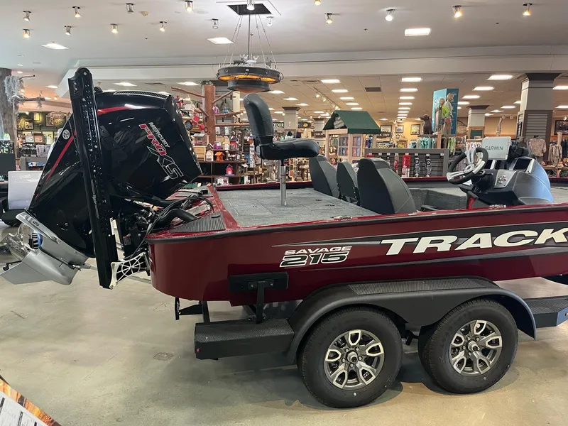 Slide: The Image of 2025 Tracker Savage 215 boat displayed indoors, featuring a powerful outboard motor. - 4